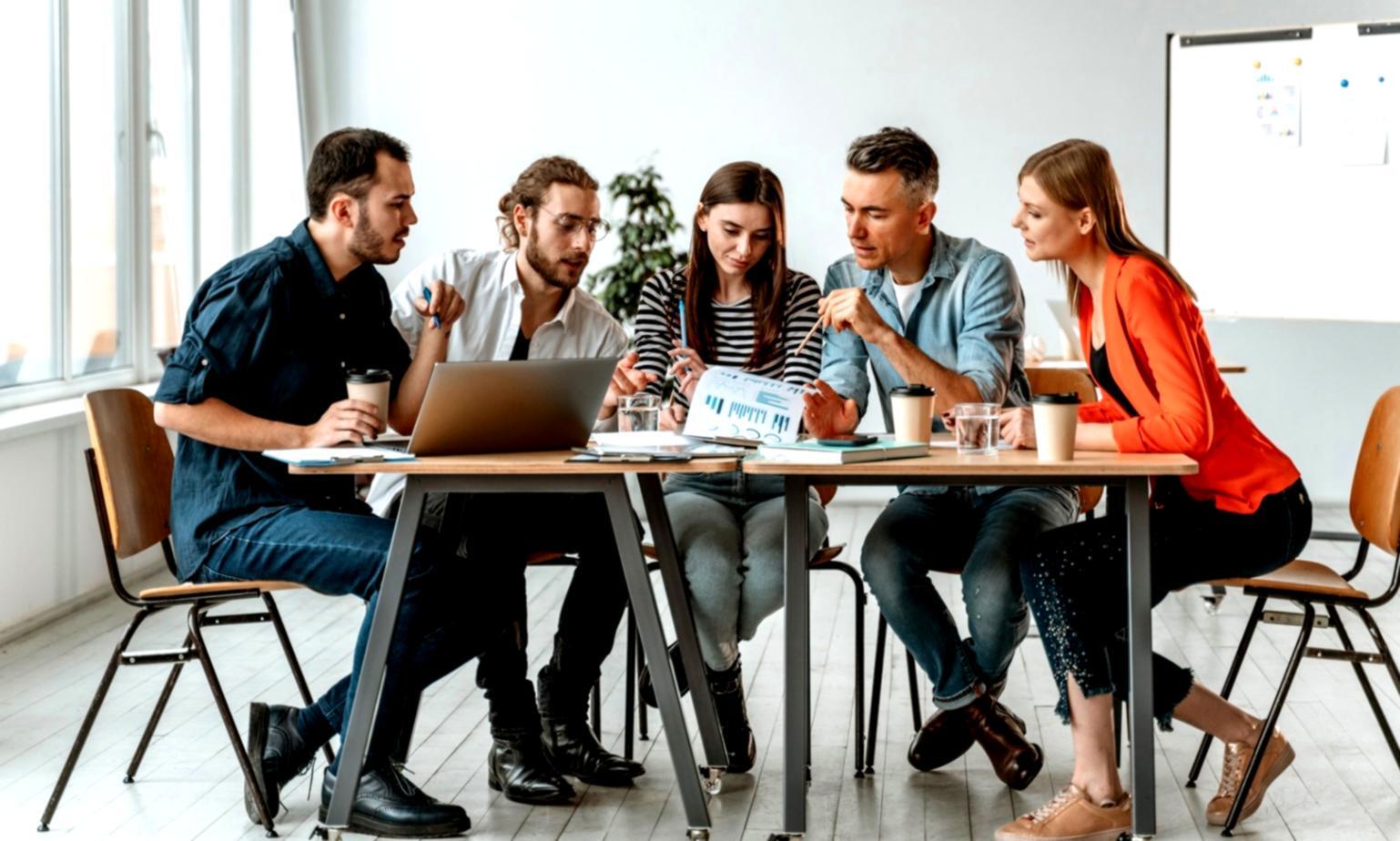 Menschen bei einer Finanzberatung mit Dokumenten und Laptops